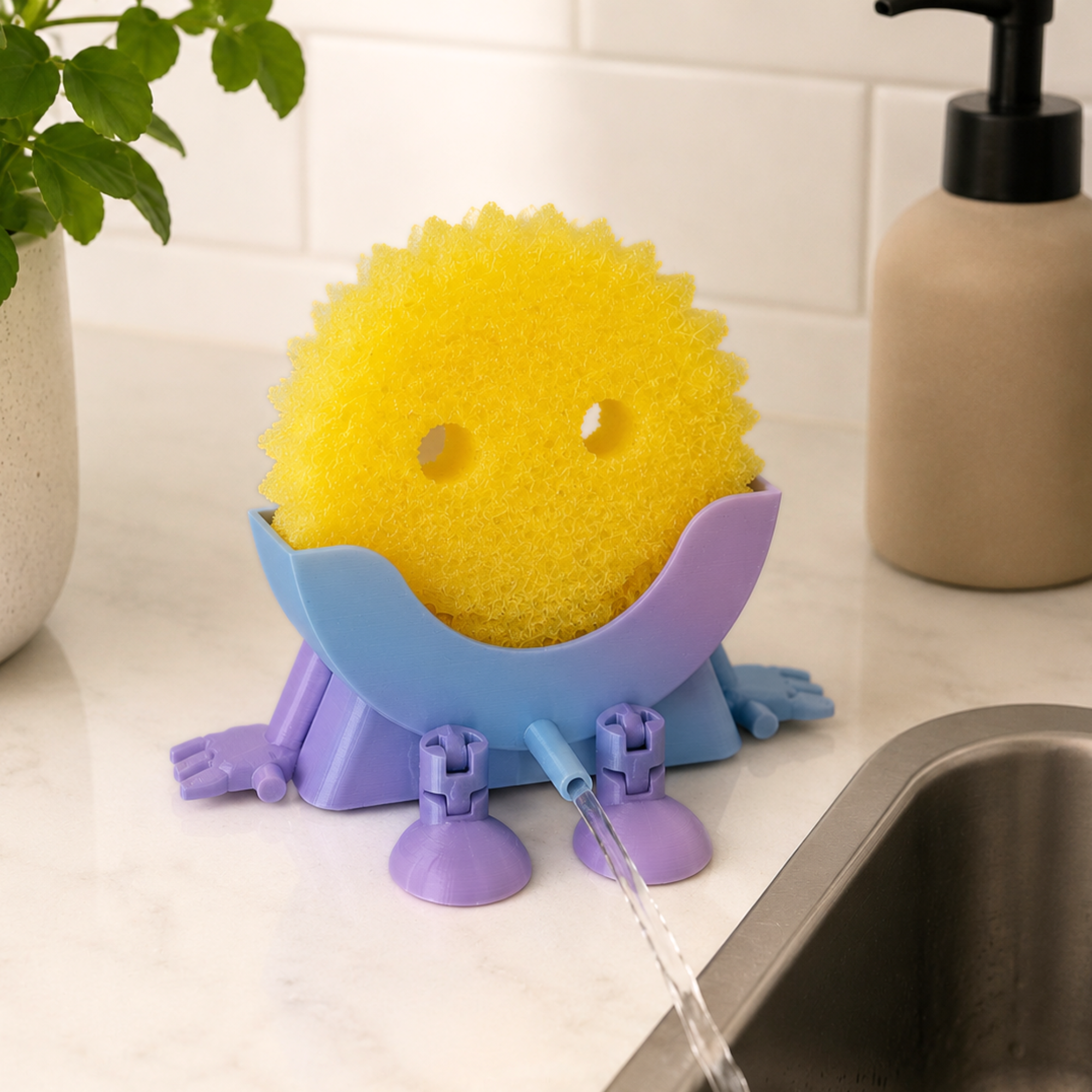 Yellow scrub daddy sponge with a purple stand on a kitchen counter, water flowing from it.